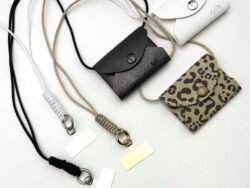 three versions of the mobile phone lanyard with wallet. One in white, one in black and one in a leopard pattern